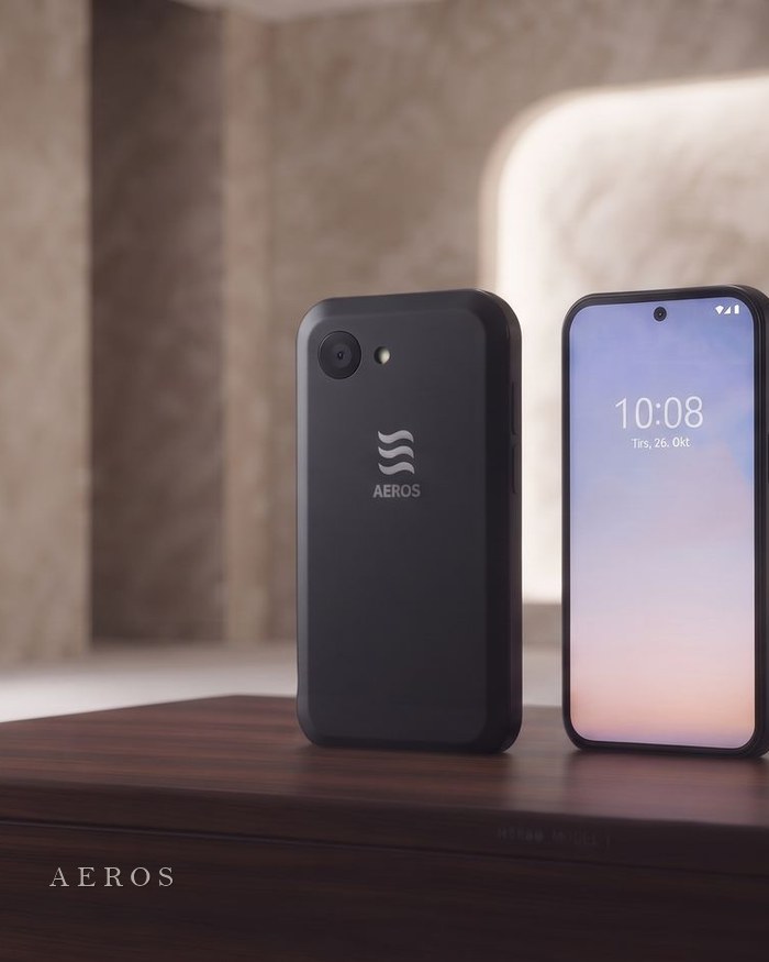 The concept phone, front and back, on a walnut surface in a warm room
